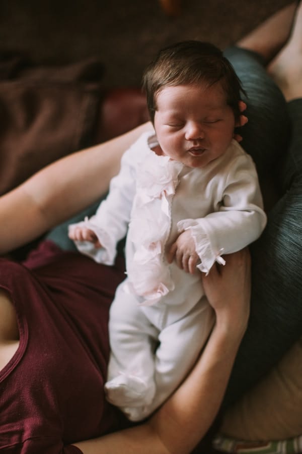 Mother holding sleeping newborn.