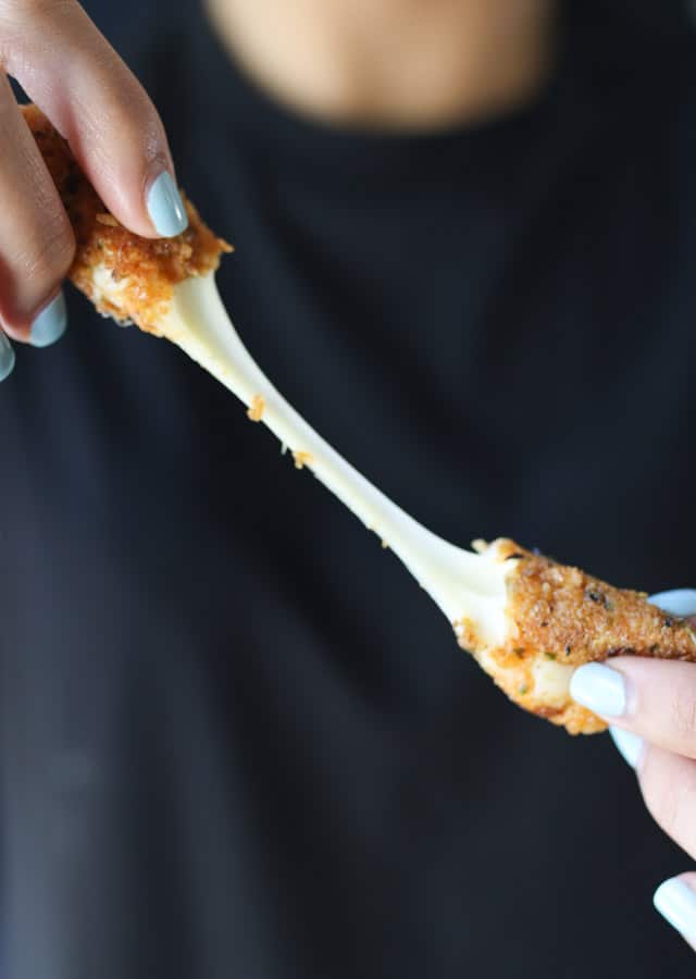 Person pulling cheese stick