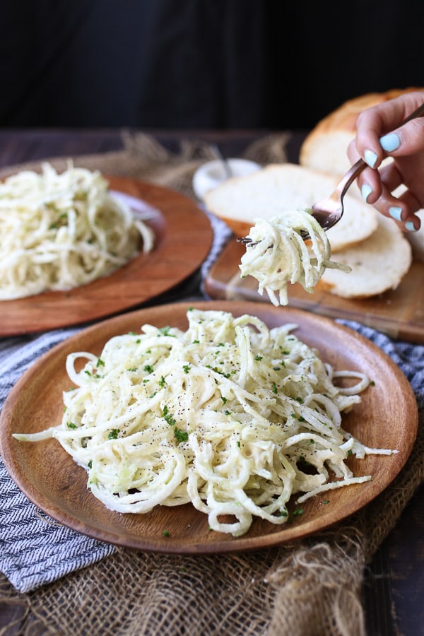 fork taking a bite of vegan keto pasta recipe from a wooden plate