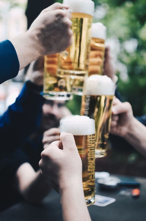 image of multiple people holding tall beer glasses
