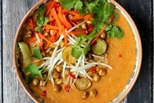 Close up image of vegan curry soup with crispy chickpeas garnished with lime and cilantro.