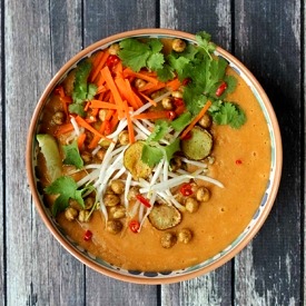 Close up image of vegan curry soup with crispy chickpeas garnished with lime and cilantro.