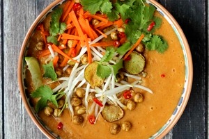 Close up image of vegan curry soup with crispy chickpeas garnished with lime and cilantro.