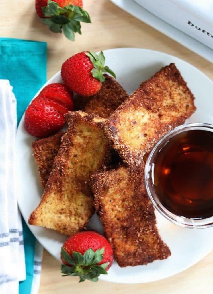 birds eye view of keto fresh toast sticks on a white plate served with syrup and berries