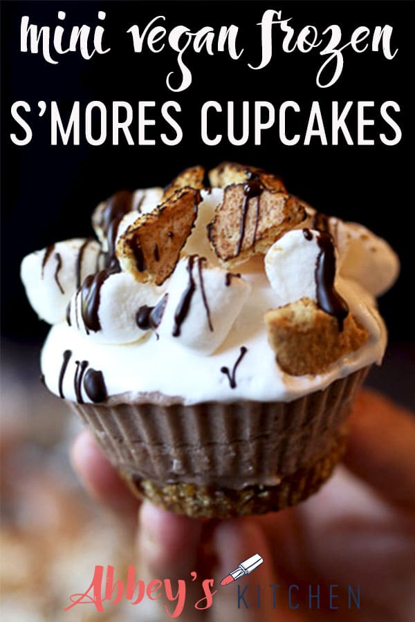 pinterest image of Hand holding s'mores cupcakes with text overlay