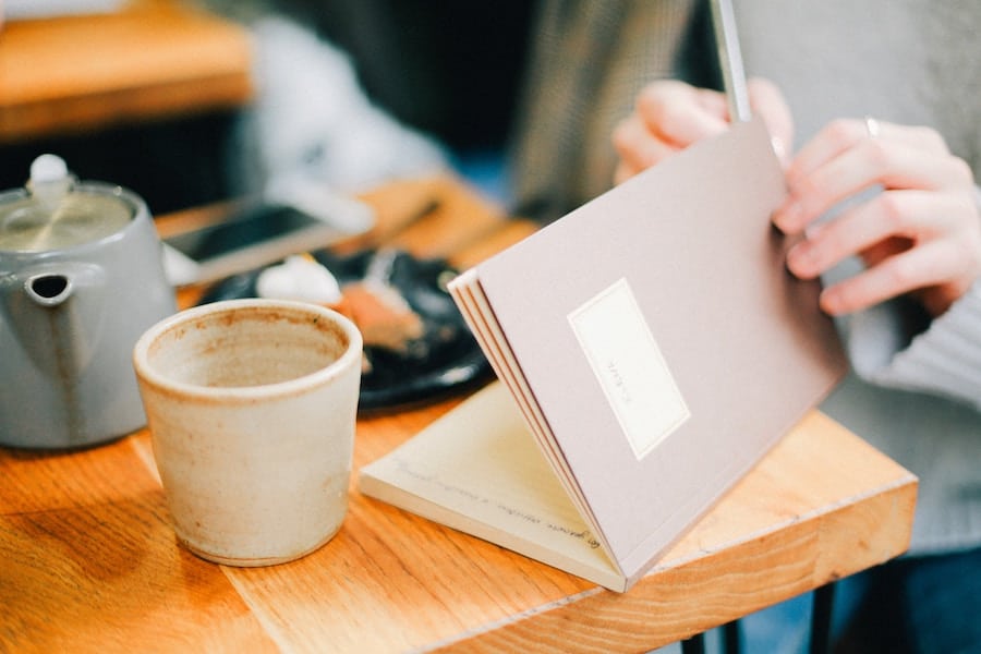 Person writing in a journal.