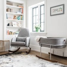 A baby room filled with furniture and a large window.