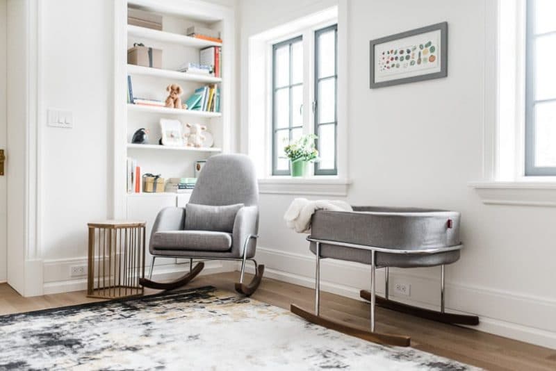 A baby room filled with furniture and a large window.