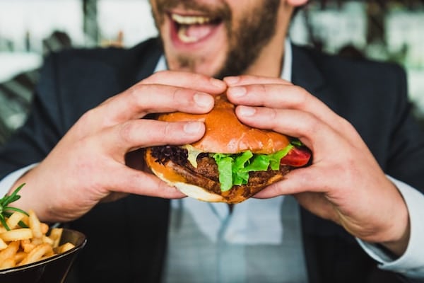 Person holding a hamburger on a cheat day.