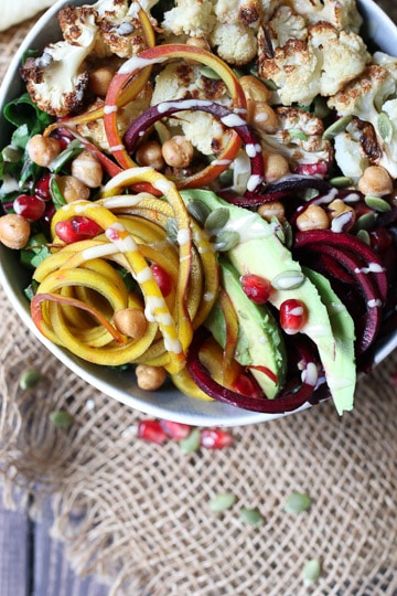 close up of vegan power bowl in a white bowl garnished with tahini