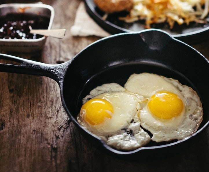 Two fried eggs in a cast iron skillet.