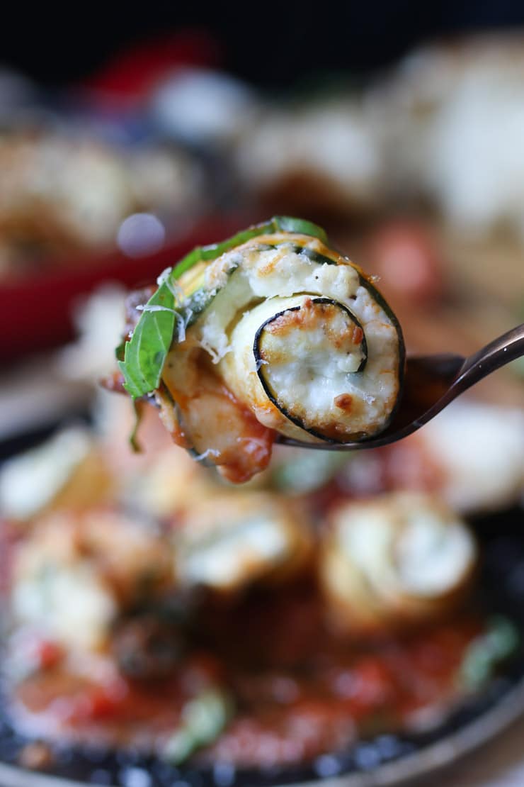 Zucchini lasagna roll ups on a fork.