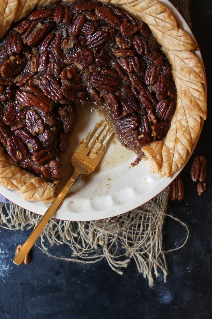 Birds eye view of homemade pecan pie with a slice taken out in a white pie dish.
