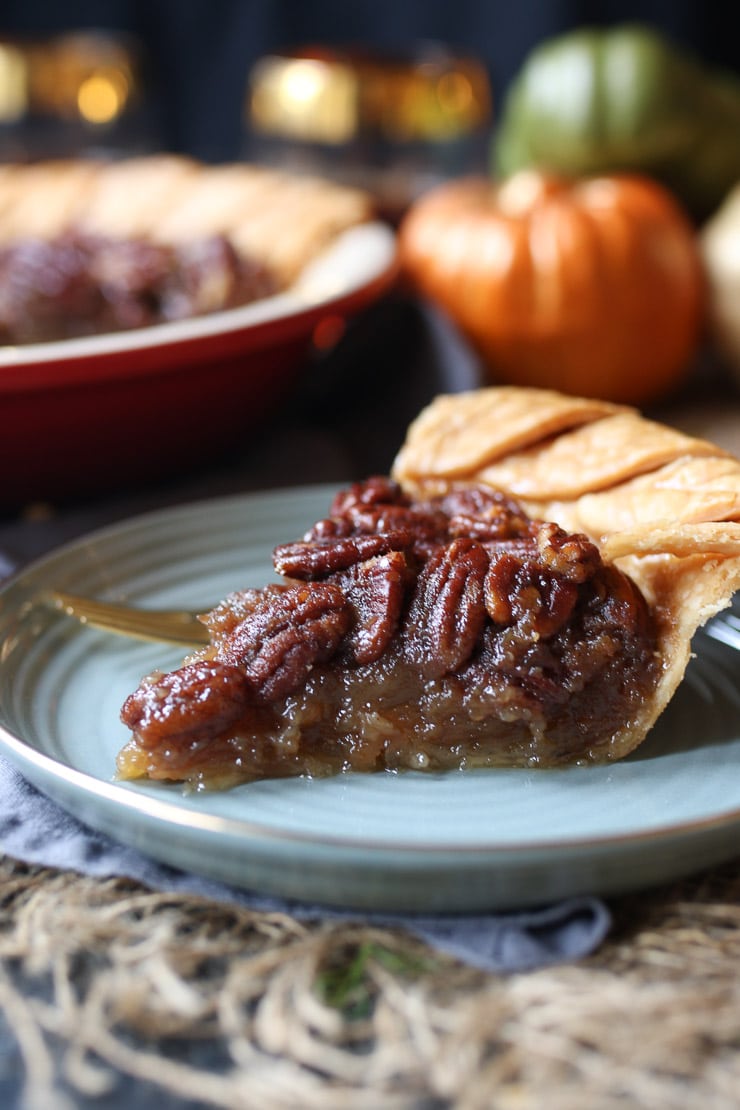 Slice of vegan pecan pie on a grey dish for thanksgiving.