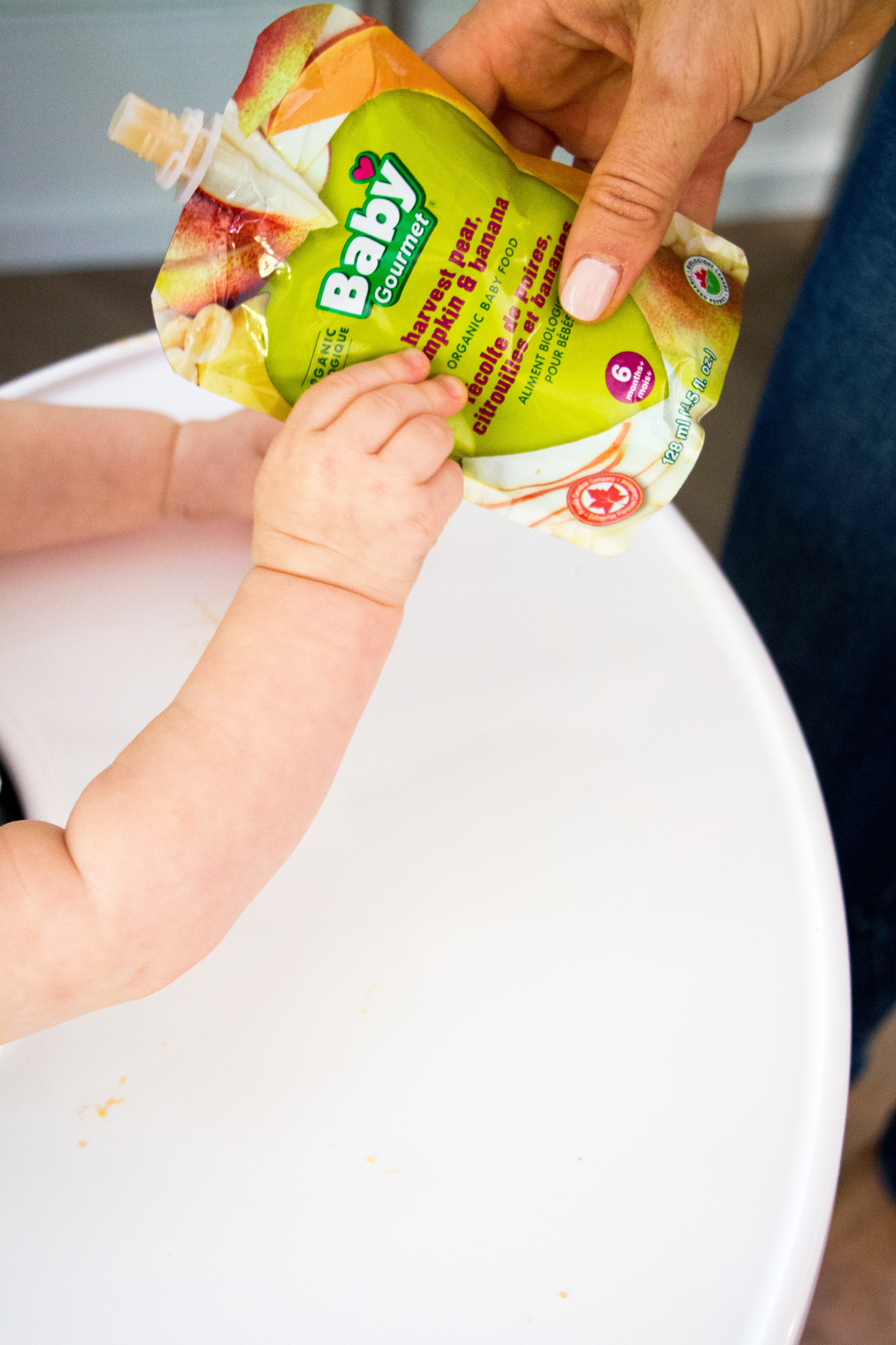 baby's hand holding baby food