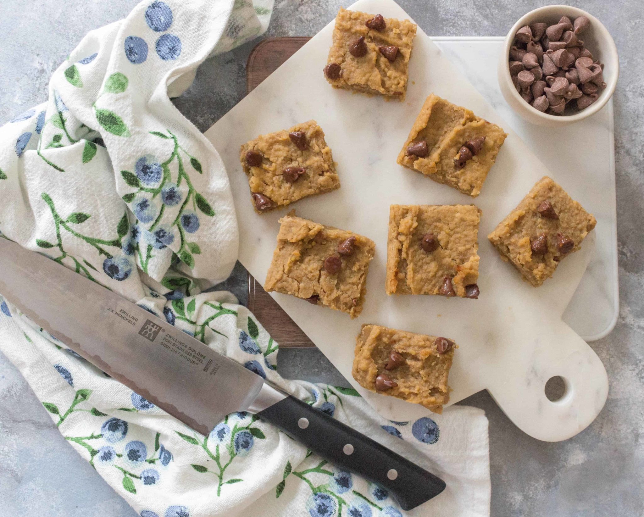 birds eye view of gluten free chickpea peanut butter blondies on a white serving board