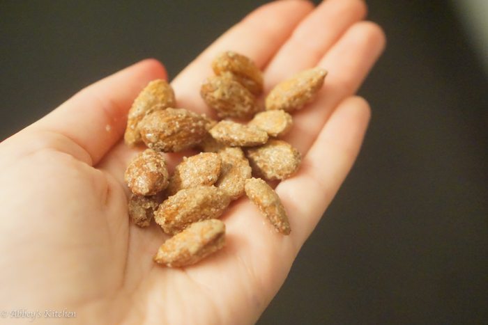 close up of hand holding gluten free cinnamon spiced almonds