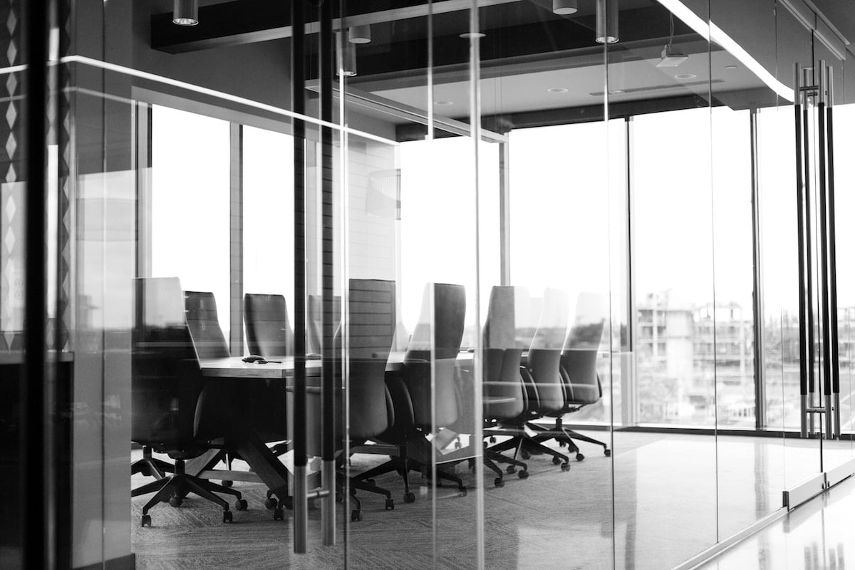 Conference room viewed through a glass wall.