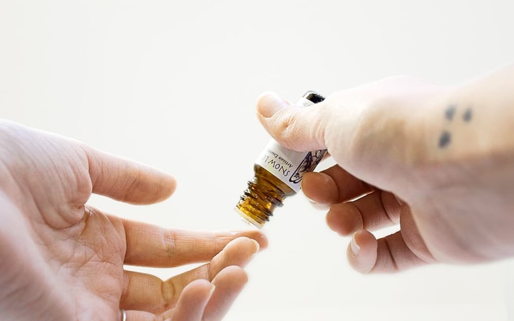 Hands using CBD oil.