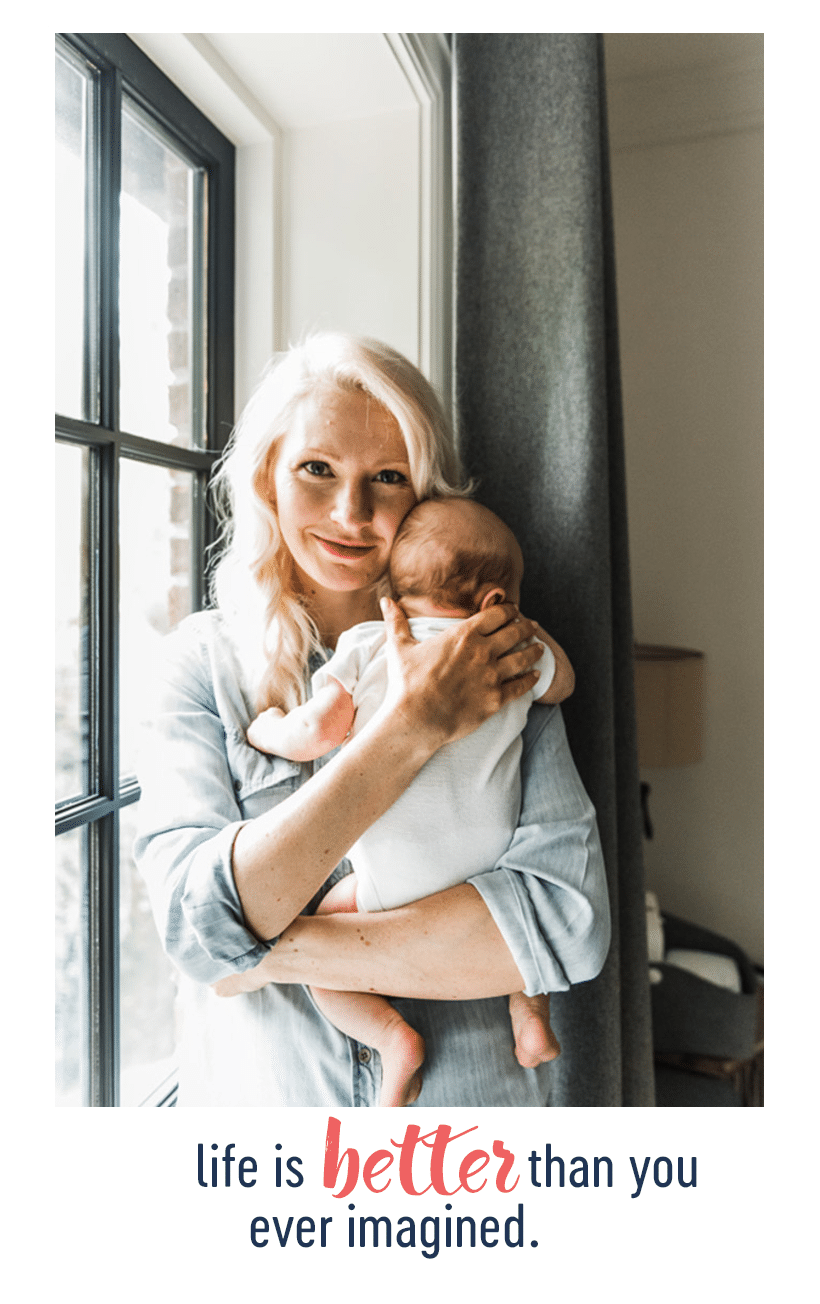 abbey holding baby E next to a window