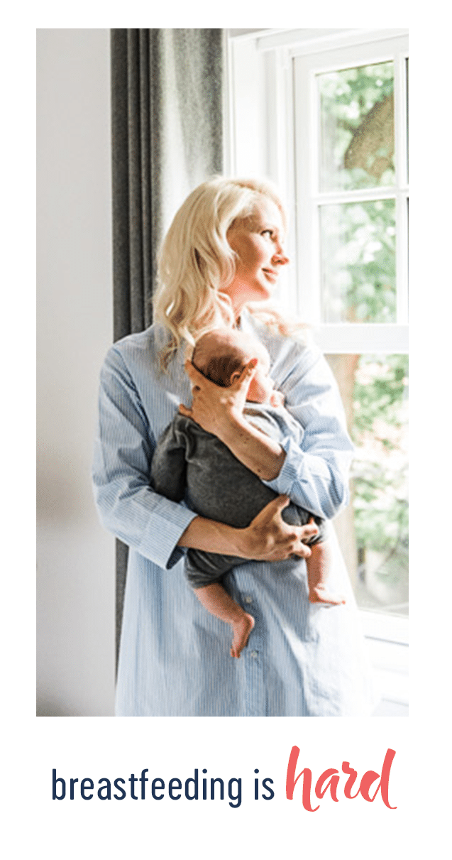 abbey holding baby E next to a window