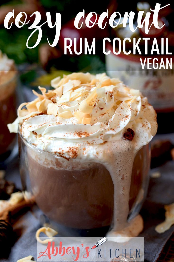 pinterest image of warm coconut rum cocktail in a clear glass garnished with whipped cream with text overlay