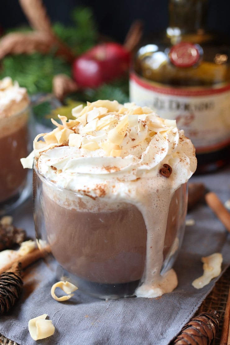 Coconut rum cocktail in a clear glass garnished with whipped cream.