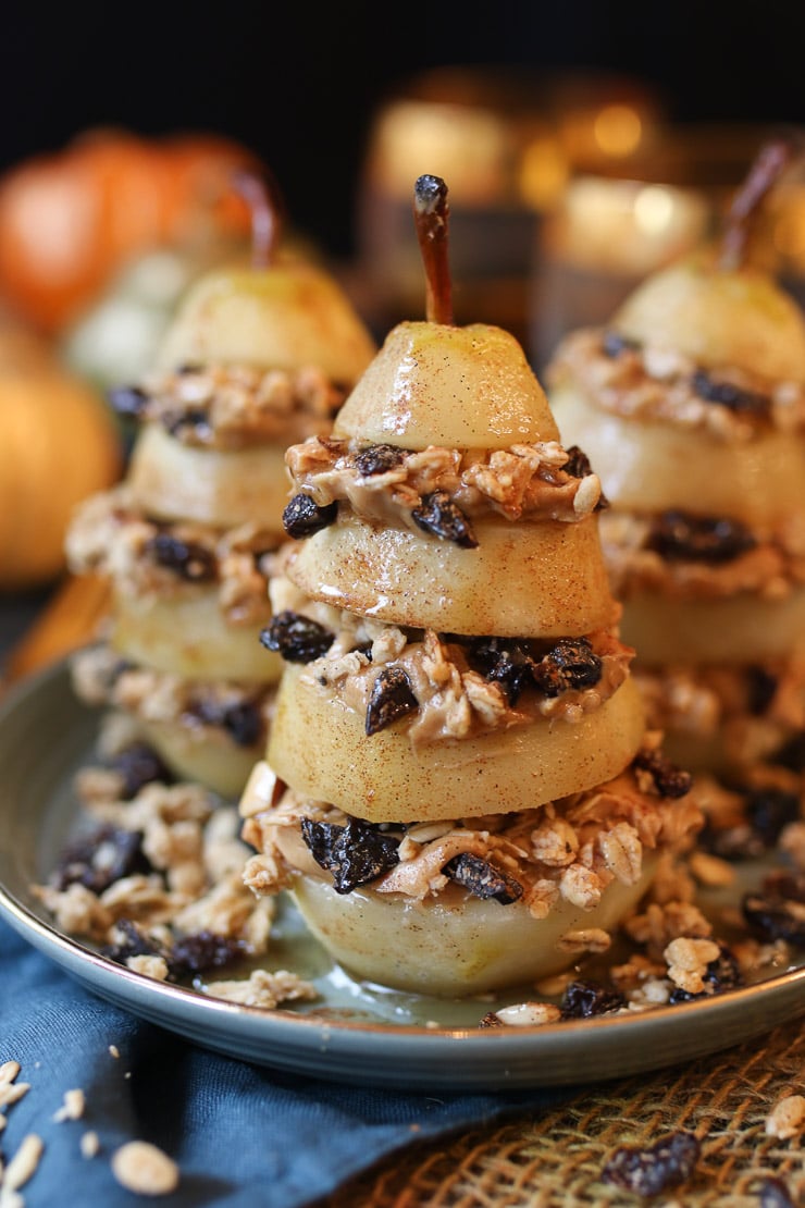 three granola layered poached pears on a grey plate