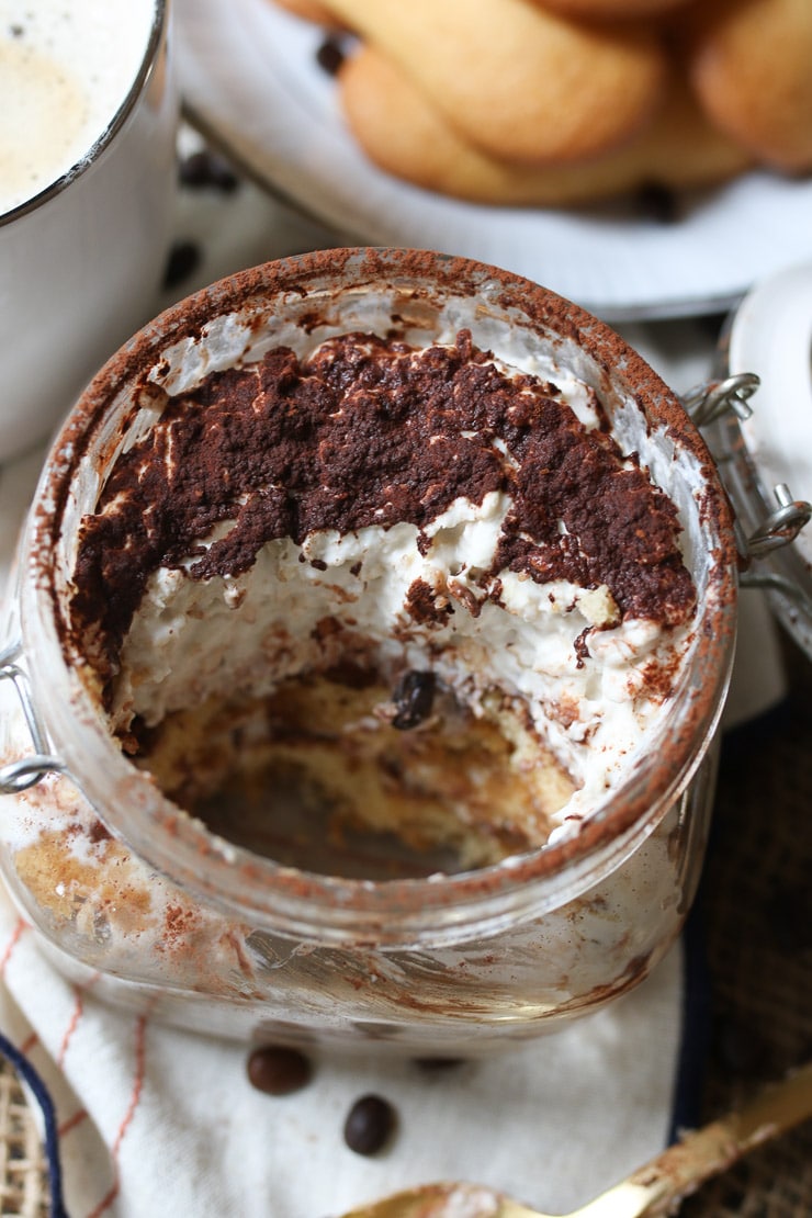 close up of half eaten tiramisu protein oatmeal in a glass jar 