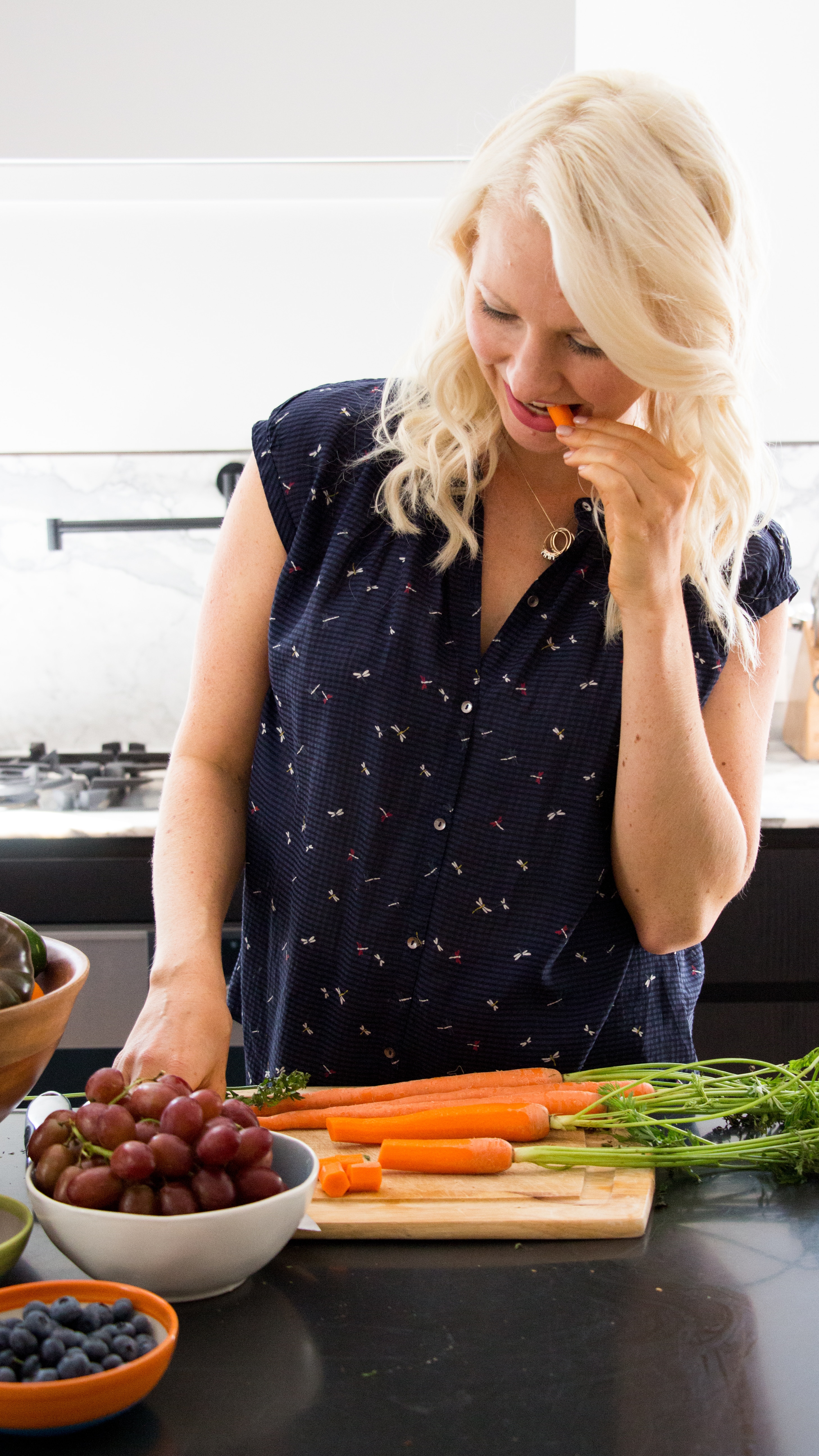 abbey eating vegetables standing up in the kitchen