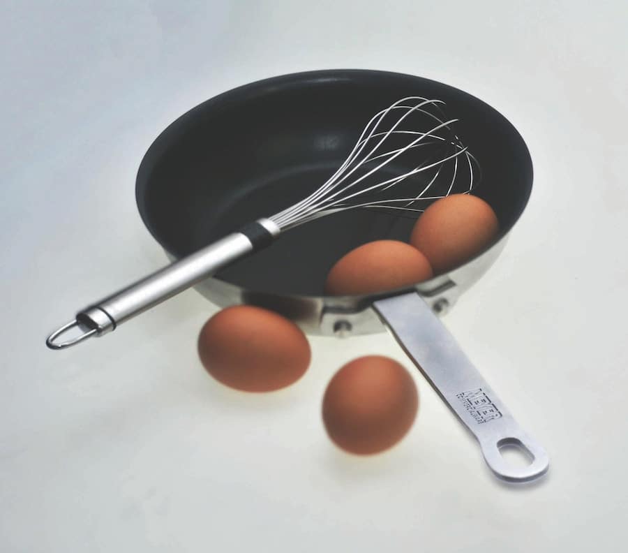 eggs and a whisk in a nonstick pan