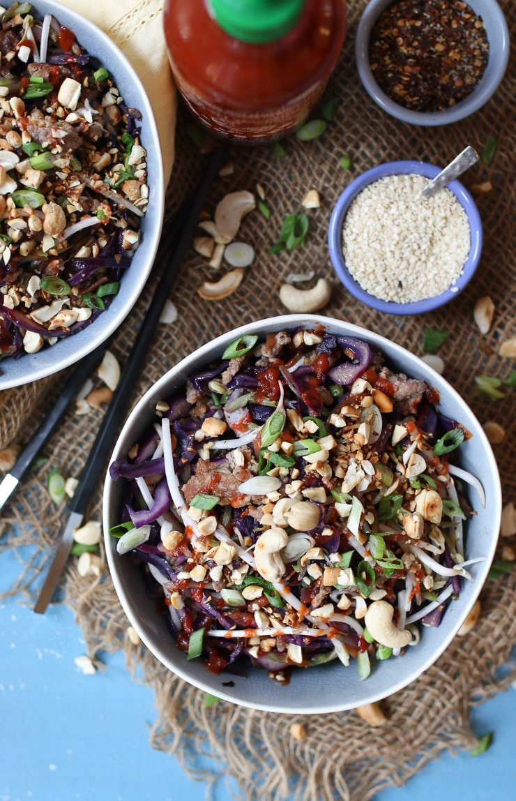 Birds eye view of grey bowl containing keto egg roll in a bowl recipe garnished with cashews and sesame seeds.