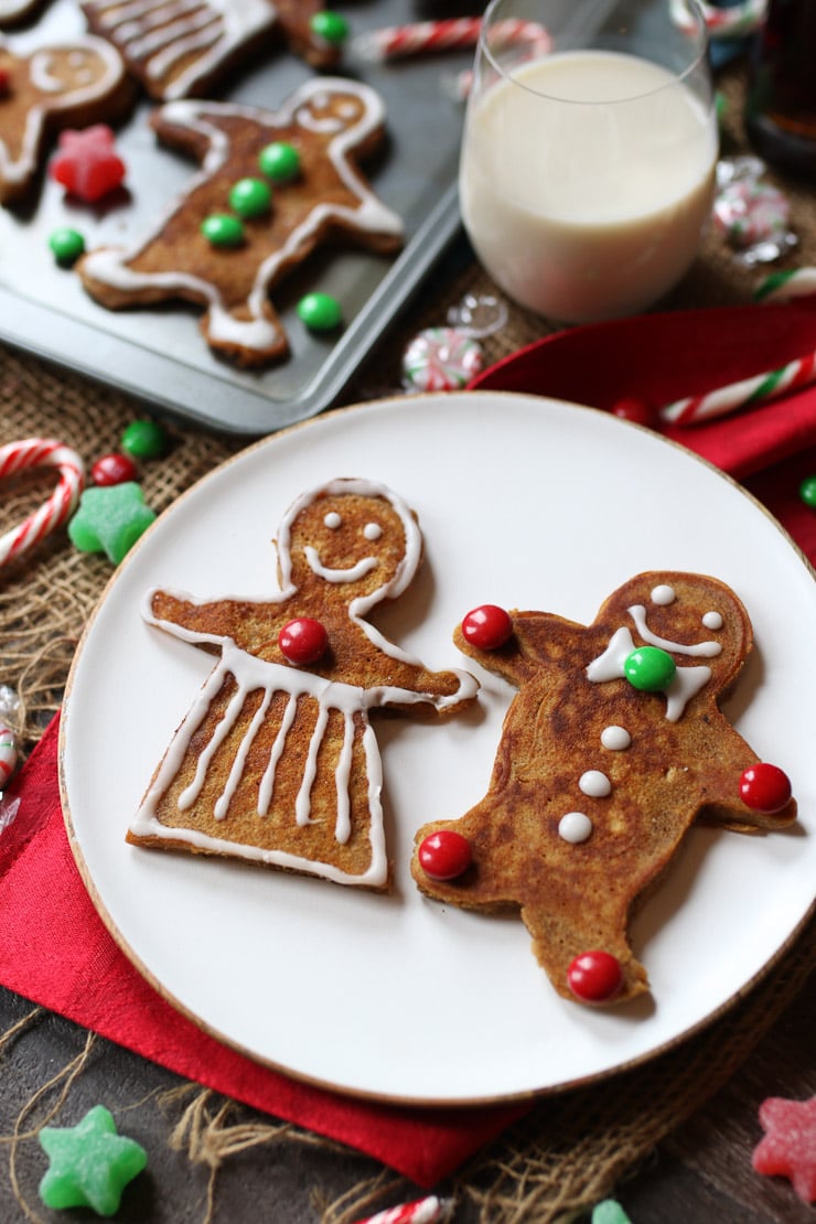 vegan and gluten free holiday pancakes on a white plate garnished with icing and candy 