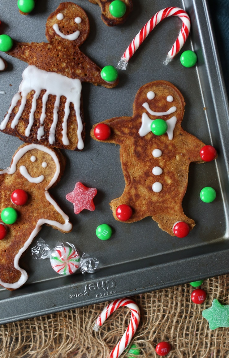 Birds eye view of vegan and gluten free holiday pancakes garnished with icing and candy.