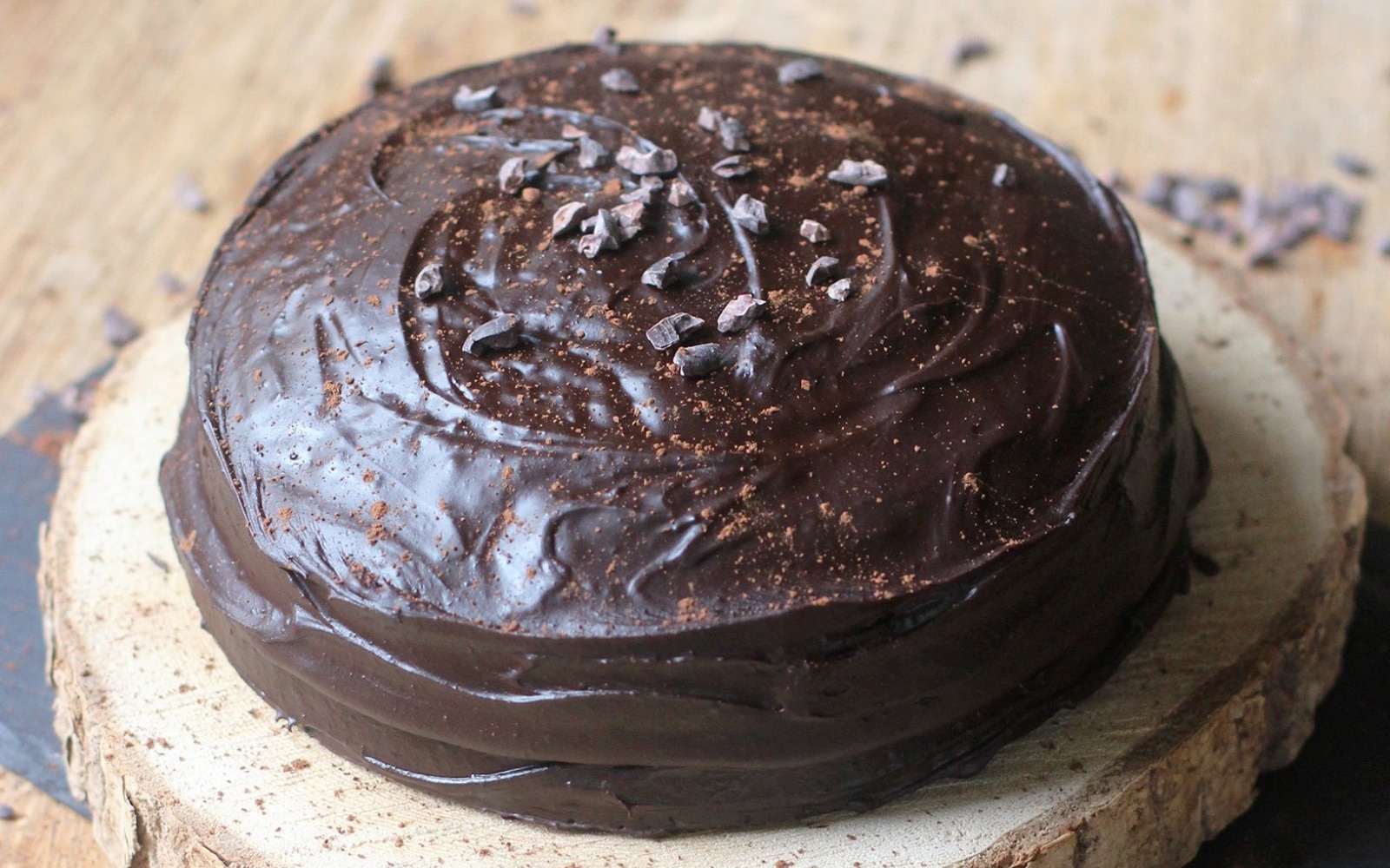 A close up of a piece of chocolate cake with chocolate frosting.