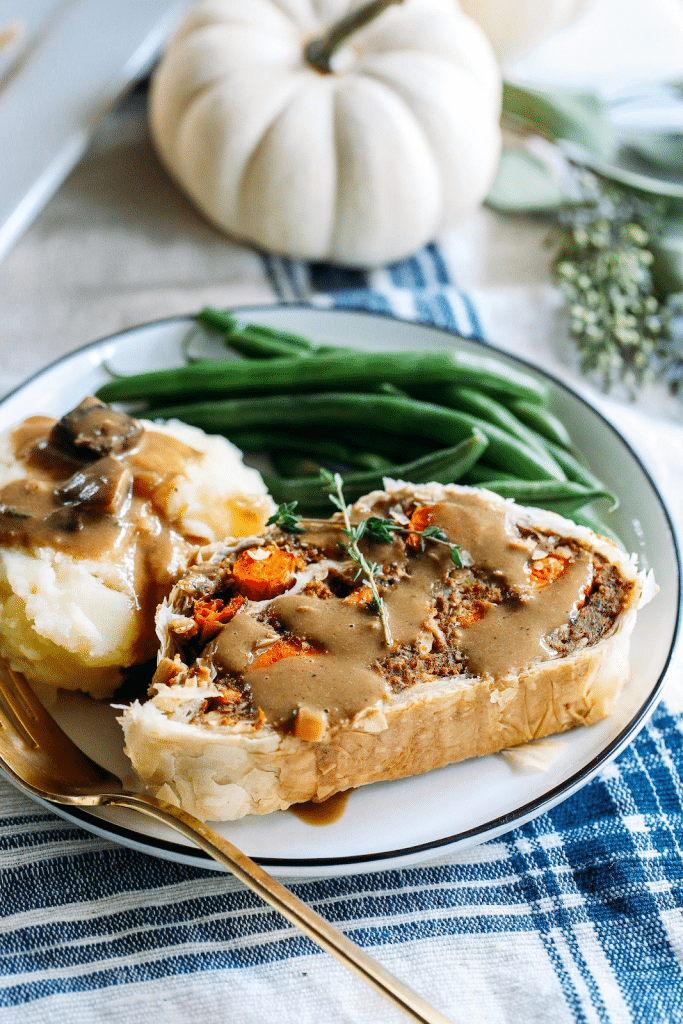 holiday vegan main dish on a white plate garnished with fresh herbs.