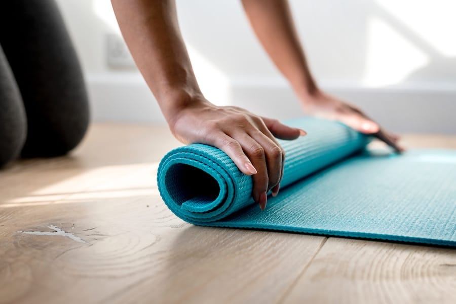 person rolling a yoga mat