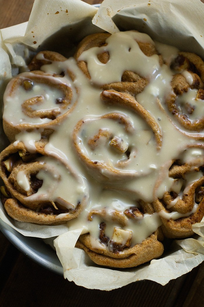 Cinnamon buns with icing in a baking tray.