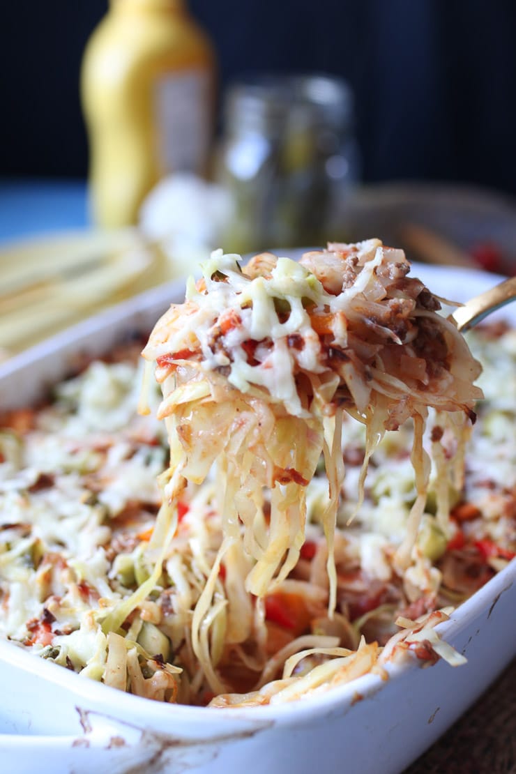 Spoon lifting out serving of cabbage casserole. 