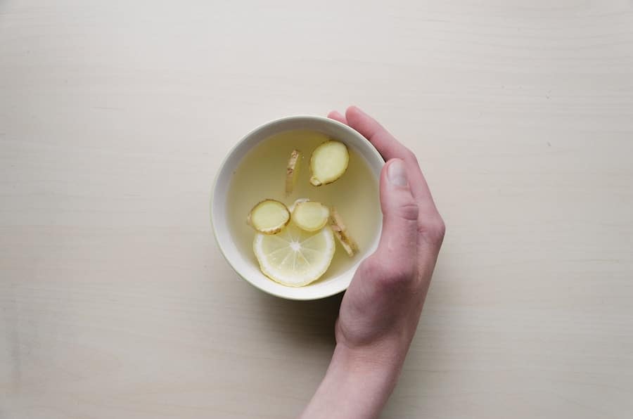 Hand holding a mug with lemon and ginger