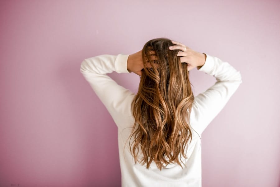 Woman holding her hair from the back.