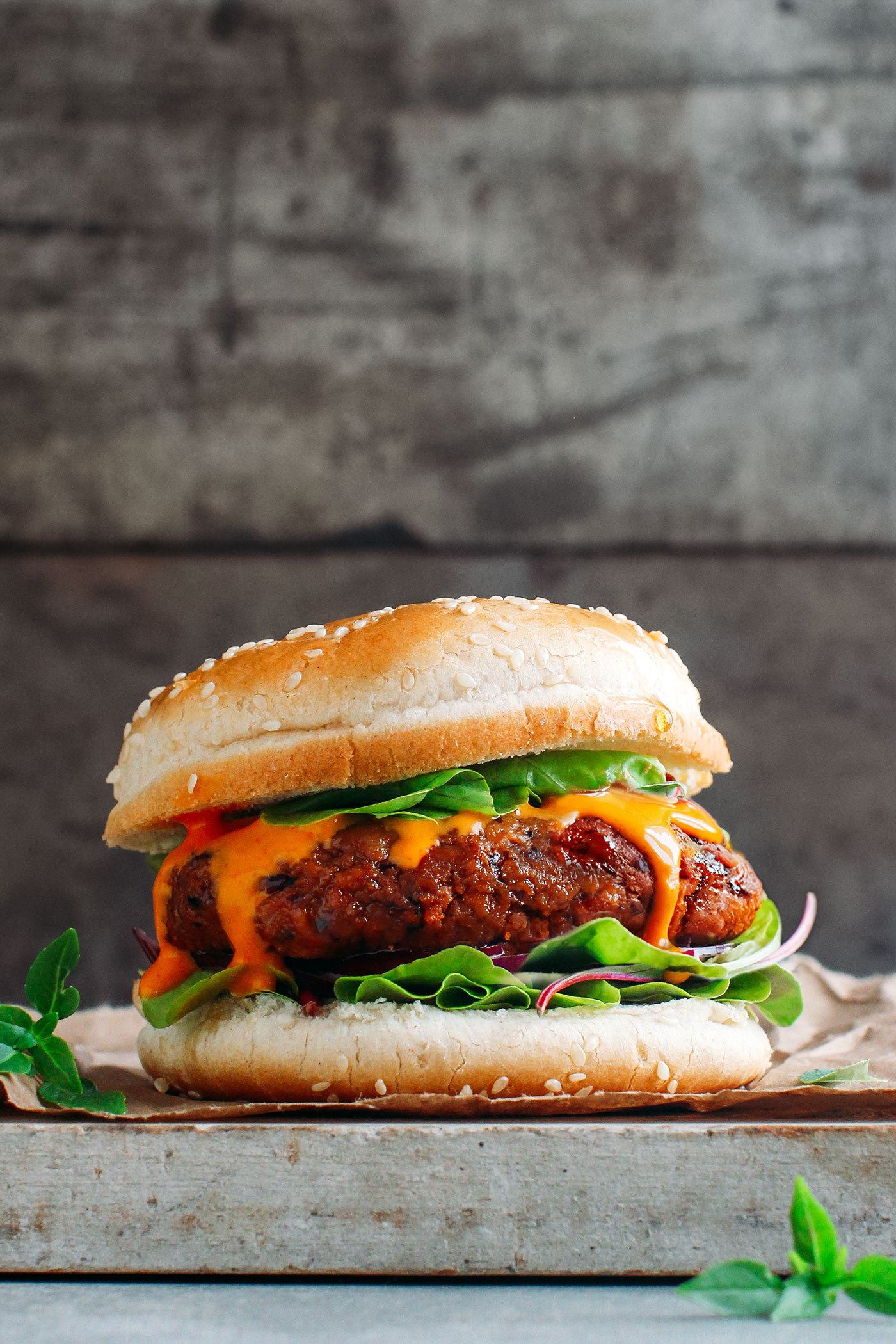 A burger with lettuce and melted cheese on the patty.