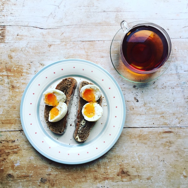 Birds eye view of eggs and toast on a white plate as a postpartum hair loss remedy.