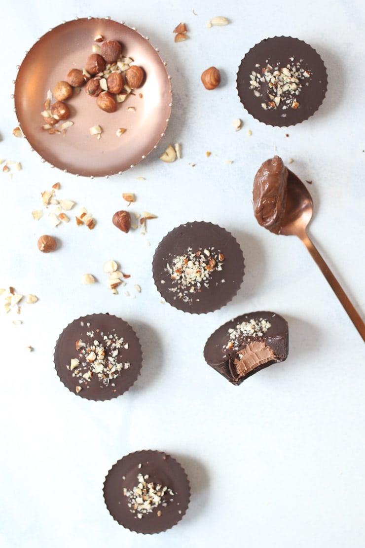 Birds eye view of vegan hazelnut and chocolate cheesecake cups garnished with chopped hazelnuts.