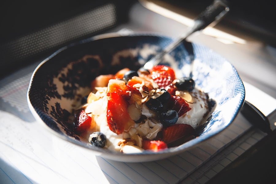 Food in a blue bowl with a silver spoon discussing allergy prevention tips. 