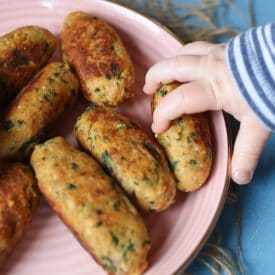 Baby grabbing a salmon sweet potato fritter.