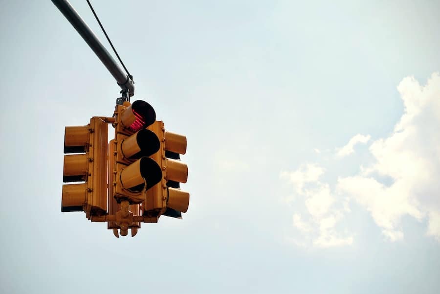 Four way traffic light against the sky.