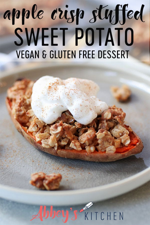 Close up of sweet potato stuffed with apple crisp topped with vegan cream on a grey plate.