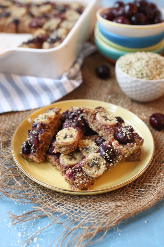 Yellow plate with cherry almond baked oatmeal fingers.