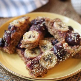 Close up of cherry almond baked oatmeal baby finger on a yellow plate.